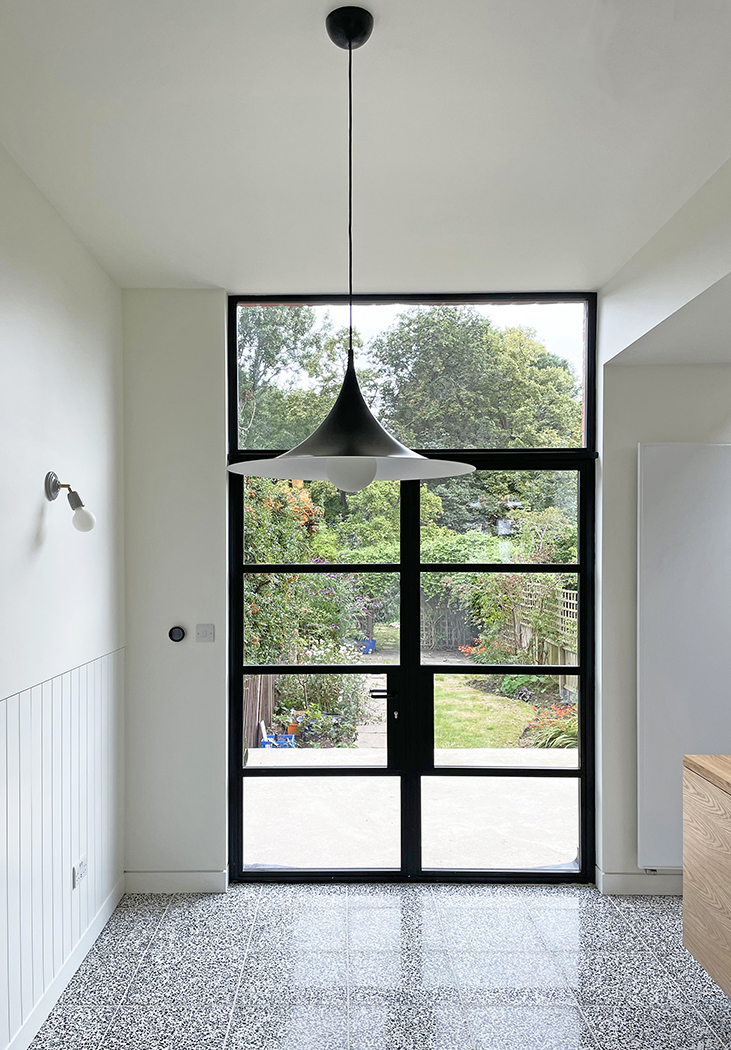 Heritage double doors access the rear garden. Contemporary panelling and Terrazzo floor tiling
