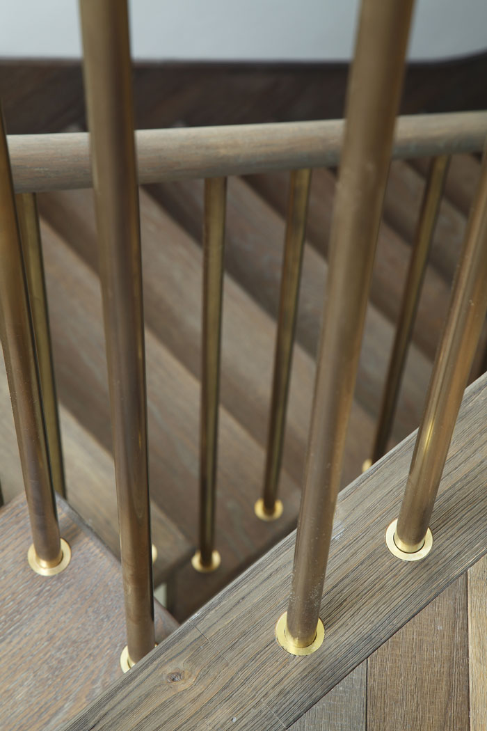 Detail of brass balustrade and oak floor.