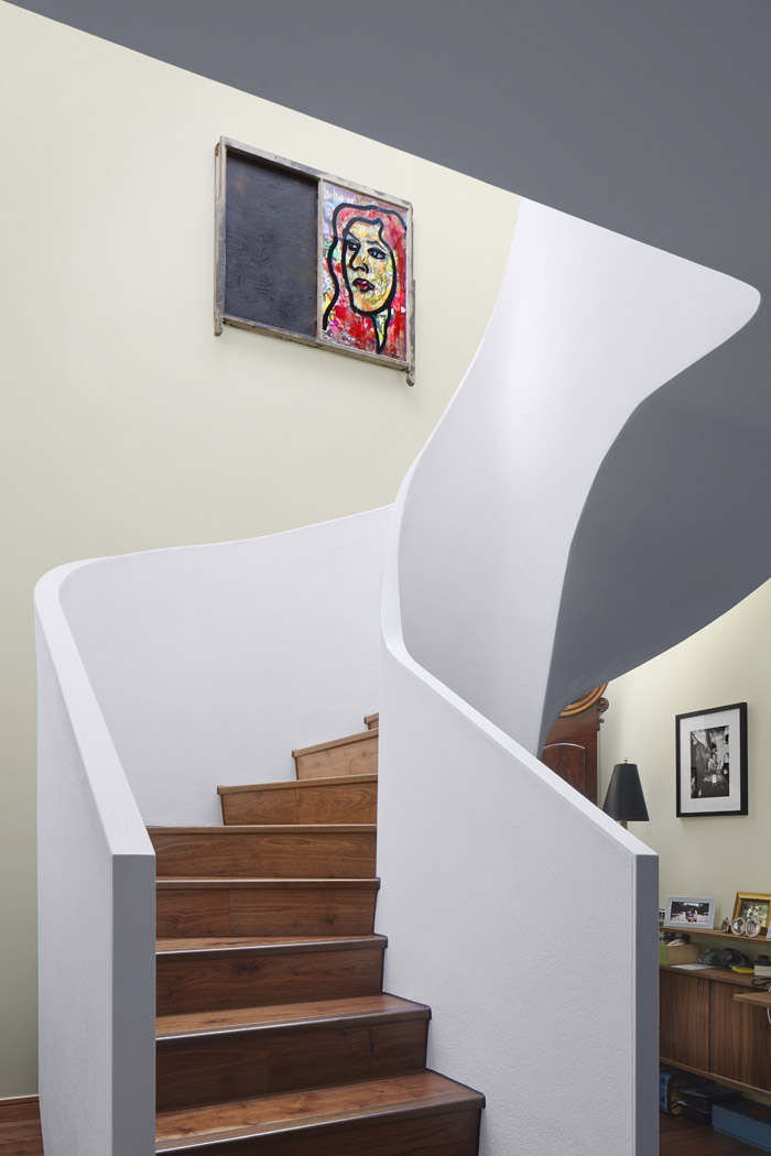 Curved staircase detail, with plastered balustrade and soffit, continuous Corian handrail detail and timber treads and rise.