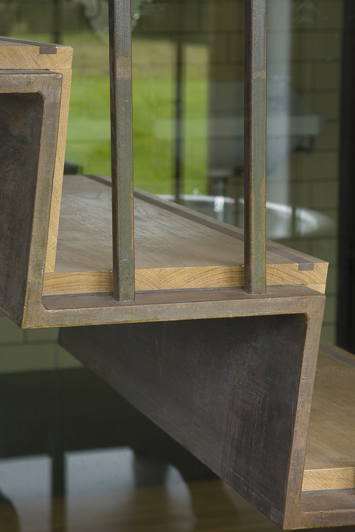 Detail folded metal staircase. Patinated finish and oak treads.