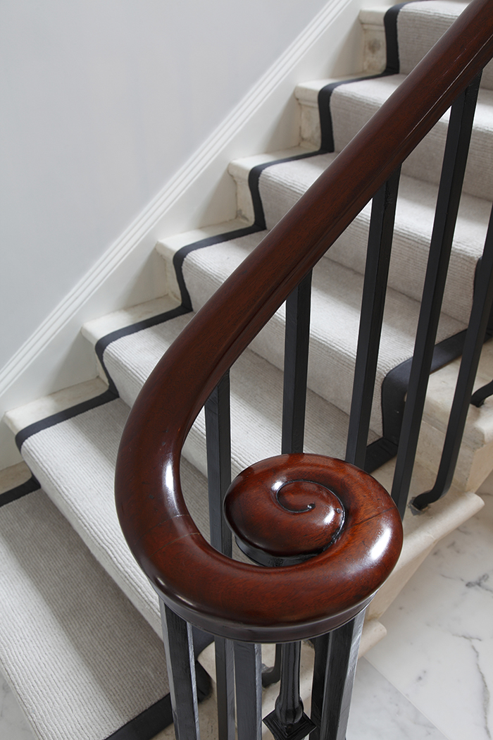 Curved, cast, white concrete staircase, with rebated stained oak treads and riser. Brass balustrade and stained oak handrail