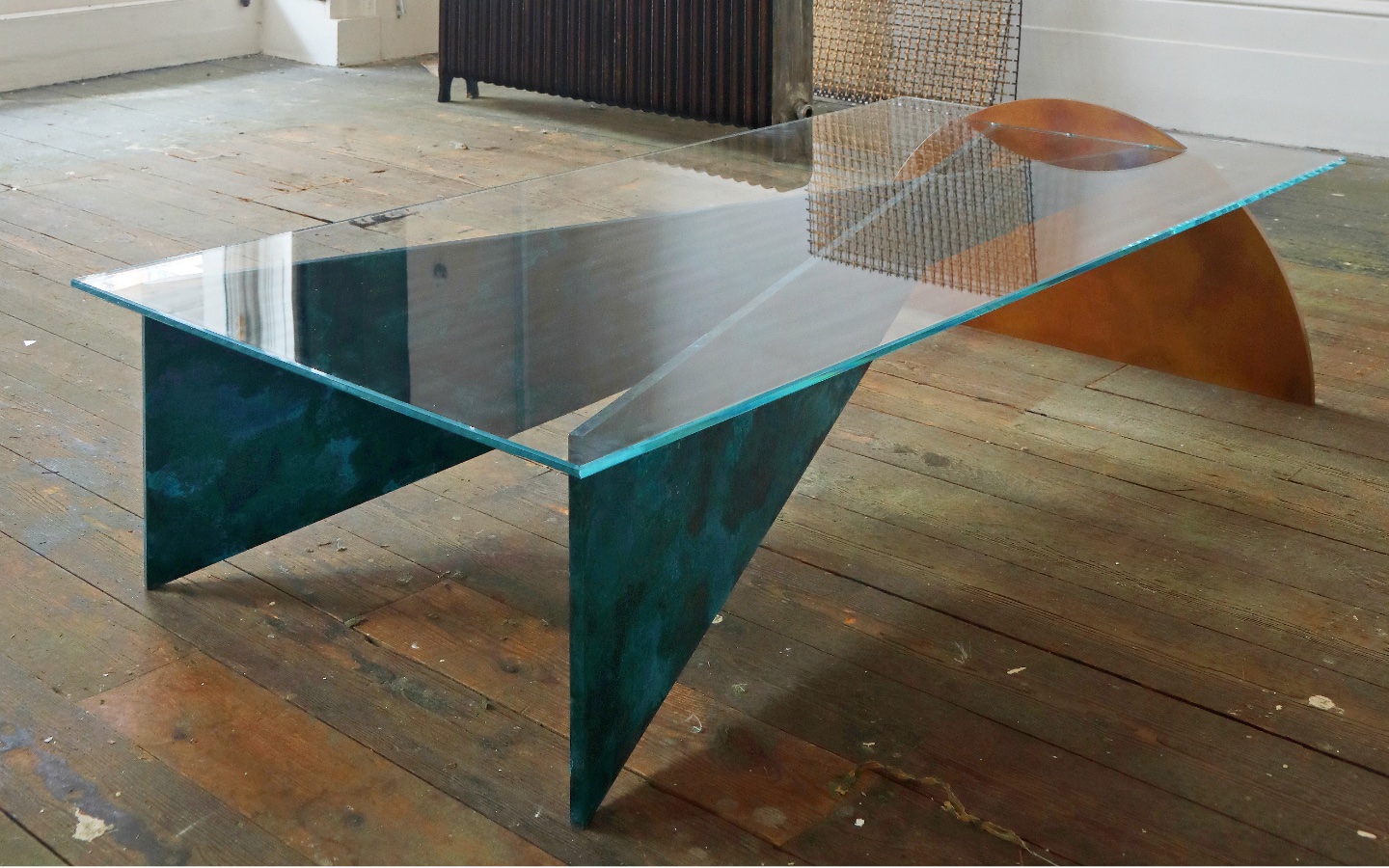 Thonis Table designed by Studioloop. Geometric shapes slot together to form the table structure, with low iron glass top. Patinated finishes